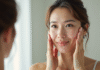 Femme se massant le visage devant un miroir lumineux